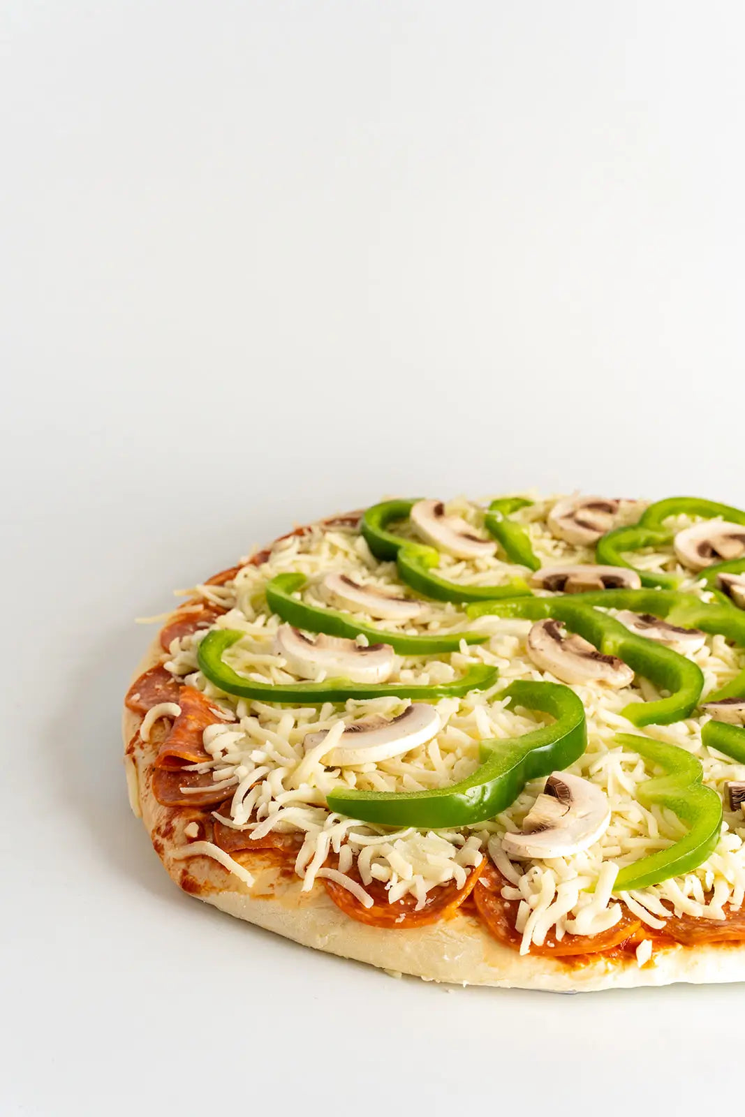 Pizza with green peppers and mushrooms on a white background
