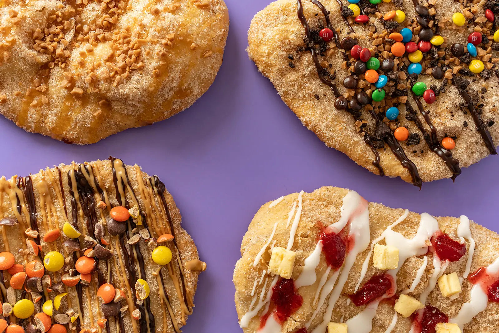 Three pastries with different toppings on a purple background