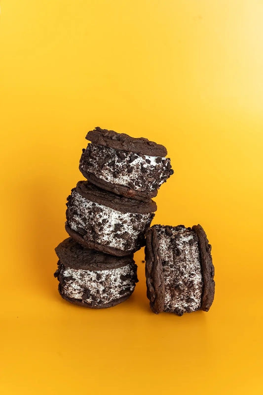Stack of chocolate oreao  ice cream sandwiches on a yellow background